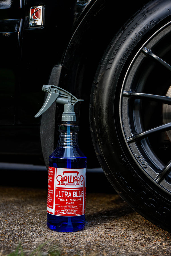 Bottle of Ultra Blue tire cleaner next to a car tire